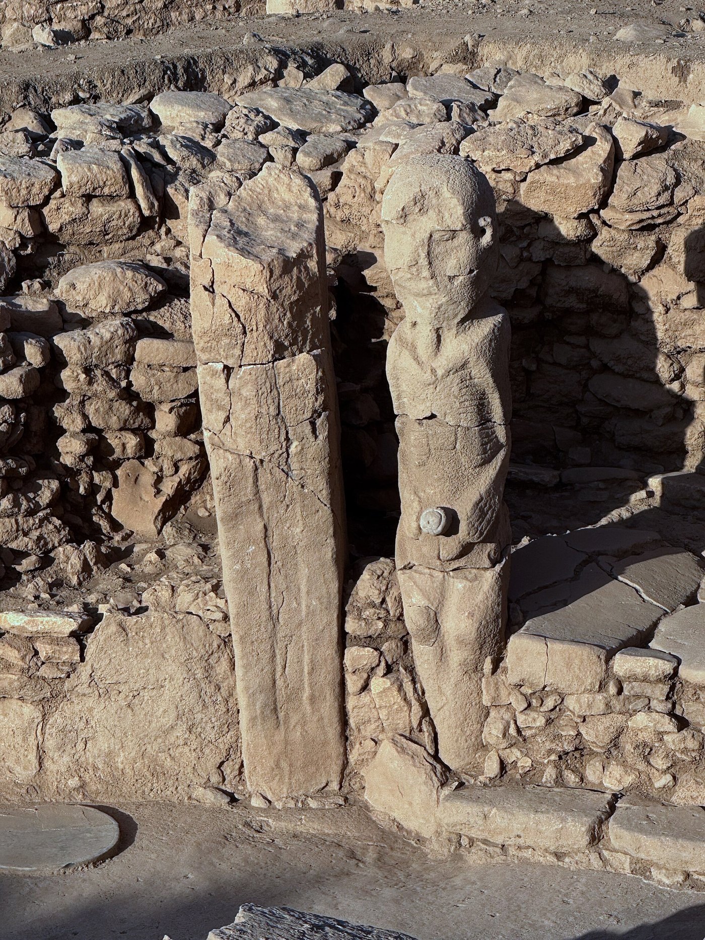 A life-size human statue carved in the round beside a pillar at Karahan Tepe, in situ in a rock-cut chamber