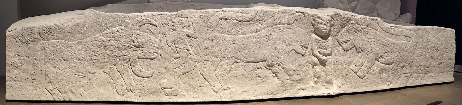 Full cast of the Sayburç bench relief showing all five figures: two leopards, two humans and a bull in one continuous scene
