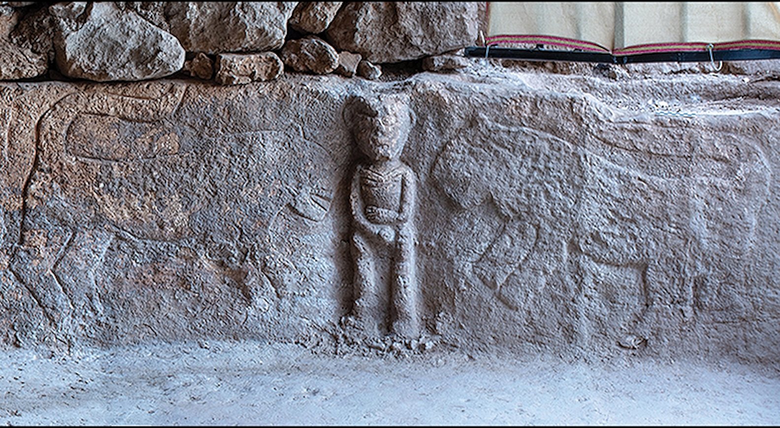 The leopard-human-leopard scene of the Sayburç relief in situ, a high-relief human figure flanked by leopards